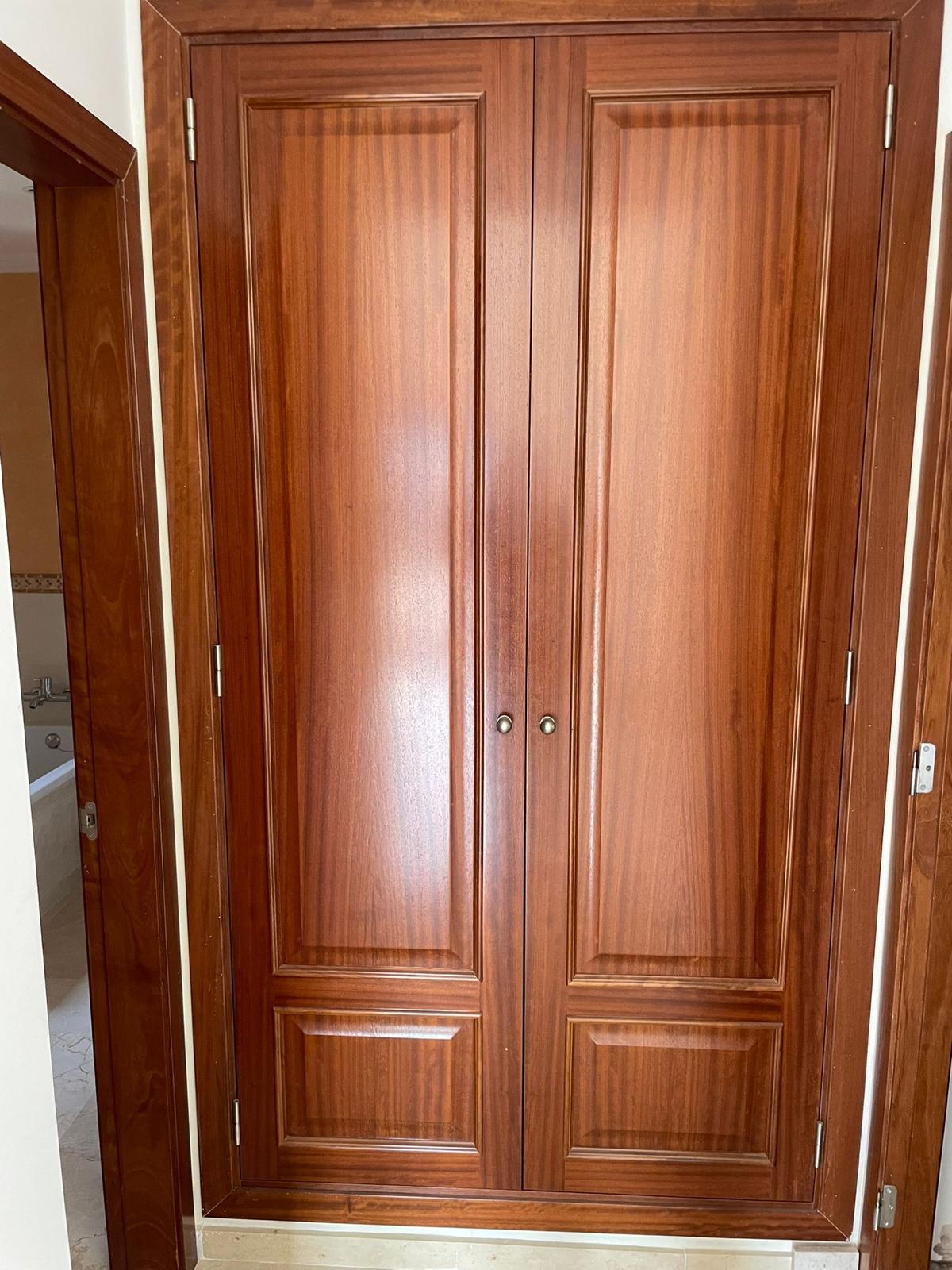 Holzschrankfront mit sichtbarer Maserung und glänzender Oberfläche